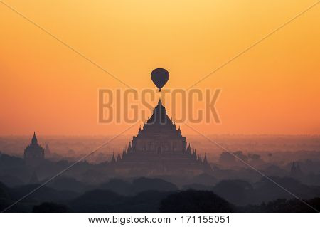 temples in Bagan with hot air balloon for traval on sun rise and mist Myanmar