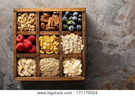 Breakfast foods, oats, cereals and fruit in a wooden box overhead shot