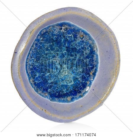 Blue ceramic handmade round bowl at the bottom of the bowl melted broken glass with bubbles of air. The vessel was lying flat on a white background with a slight shadow and reflection.