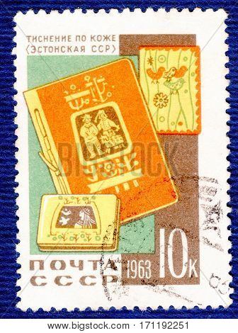 USSR - CIRCA 1963: Postage stamp printed in USSR with a picture a stamping on a skin (Estonian SSR) a cover, notebook and book, from the series "Folk handicraft". circa 1963