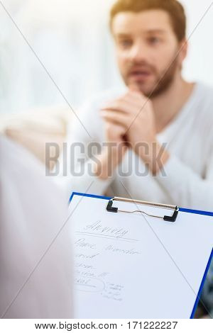 Psychologists notes. Close up of preliminary diagnosis written by a professional psychologist during the physiological session with a male patient