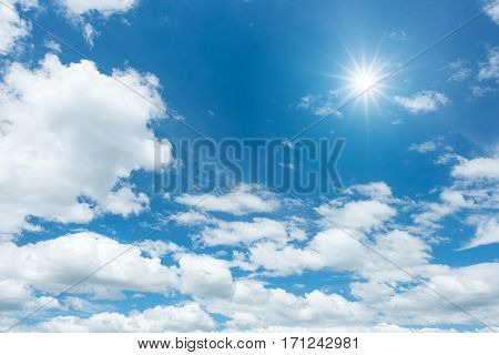 Blue sky with clouds and sun reflection