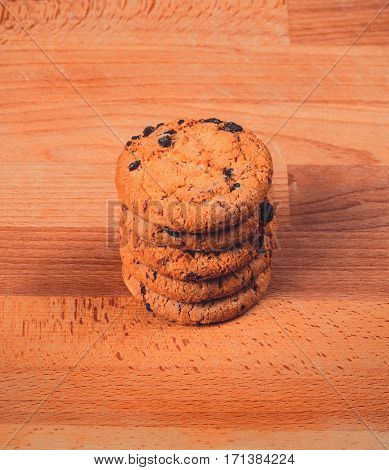 Home made chocolate cookies on wooden background. Crispy chip biscuits with chocolate and hazelnuts. Delicious fresh chocolate chip cookies.