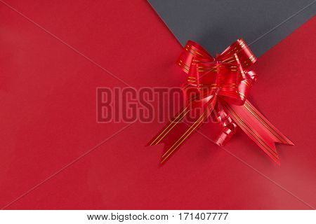 Red ribbon bow on gray and red paper. Love card concept Valentine's day theme