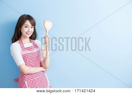 beauty housewife take rice spoon and smile isolated on blue background