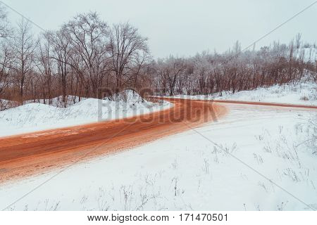 View on winter road that is red because of ore