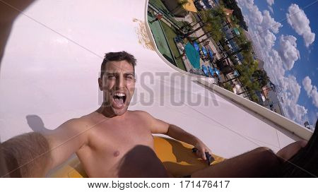 Man having fun and sliding down in a water slide