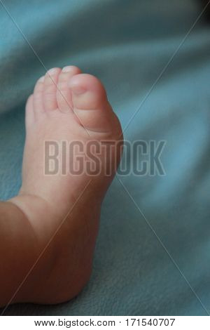 Feet of a baby on green sheet