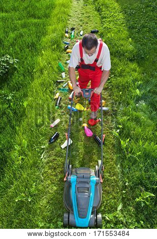 Man working against nature - concept with plastic spewing lawn mower view from above