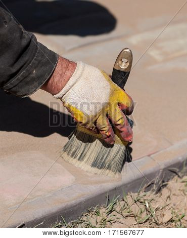 Workers laid paving tiles. Cleaning the gaps between the stones.