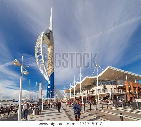 Portsmouth, UK. 16th February 2017. People are walking along the promenade at Gunwharf Quays against the backdrop of the Spinnaker Tower. Gunwharf Quays is a mixed use retail and leisure facility.
