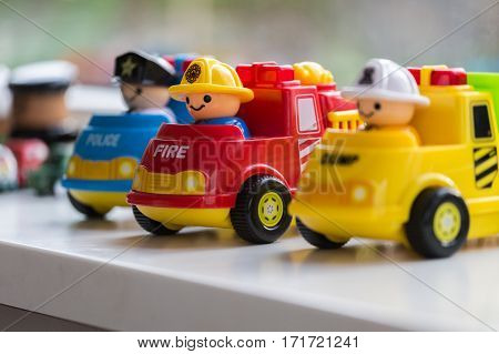 Three plastic toy cars representing the Fire Brigade Police Department and Garbage collection