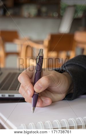 Woman hand writing on noteboook paper stock photo