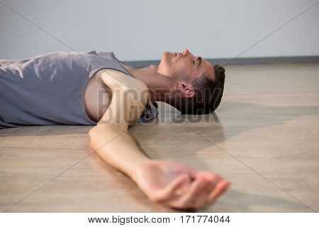 Man in yoga corpse pose in gym