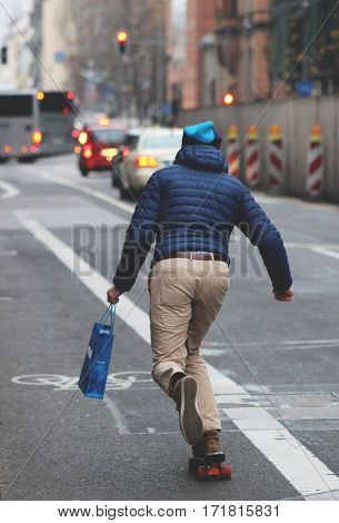 A man skating on one of a city's streets