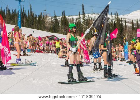 Group Of Young Happy Pretty Women On A Snowboard In Colorful Bikini With Flags.