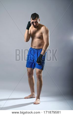 Portrait Of Kickboxer On A Gray Background.