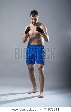 Portrait Of Kickboxer On A Gray Background.