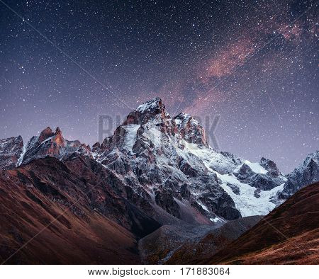 Fantastic starry sky. Autumn landscape and snow-capped peaks. Main Caucasian Ridge. Mountain View from Mount Ushba Meyer, Georgia. Europe.
