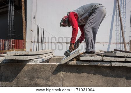 Builder Worker With Grinder Machine Cutting Concreate Floor At Construction Site