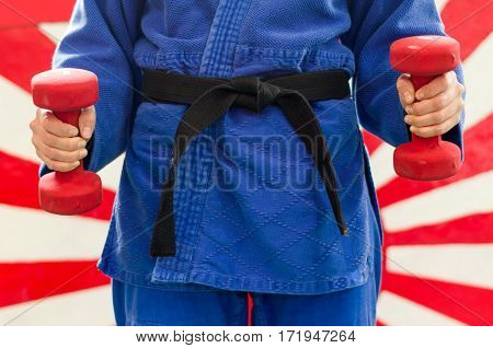 Close Up of Woman in Blue Judo Gi and Black Belt which is Train with weights and kettlebells Girya