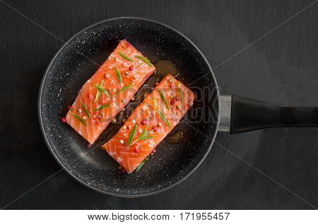 Raw salmon fish fillet with spices on frying pan
