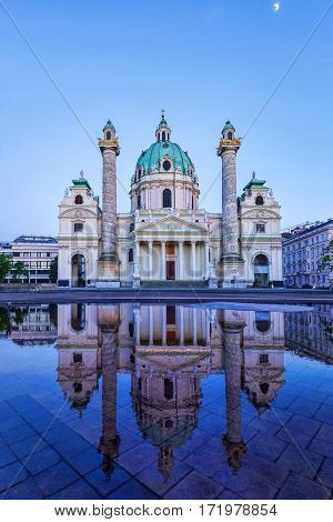 Karlskirche in Vienna Austria at sunset with reflection and shining moon in the purple sky, St Charles's church