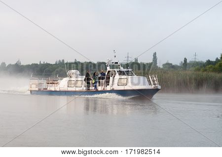 Kurchatov, Russia - JUNE 23, 2016: Reporters sail on a pleasure boat on the reservoir of Kursk NPP. Foggy morning.