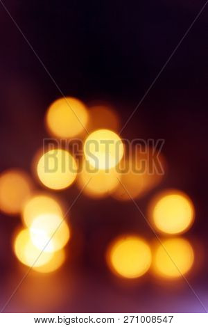 Background Of Blurry Yellow-orange Lights Of Christmas Tree Garland On Dark. Copy Space