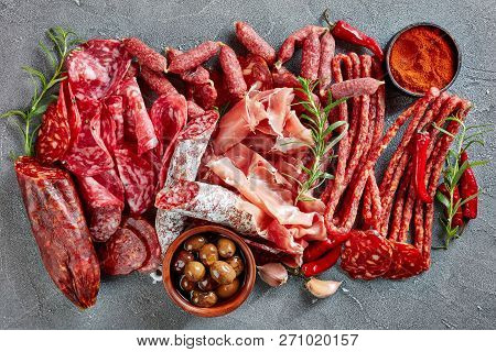 A Set Of Spanish Sausages And Dry Cured Meat - Jamon, Chistorra, Chorizo, Salchichon, Fuet, Olives, 