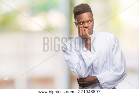 Young arabic african man wearing traditional djellaba over isolated background looking stressed and nervous with hands on mouth biting nails. Anxiety problem.