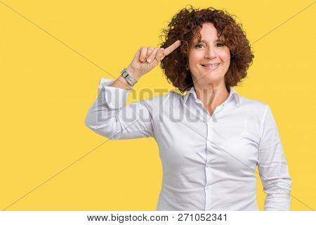 Beautiful middle ager senior businees woman over isolated background Smiling pointing to head with one finger, great idea or thought, good memory