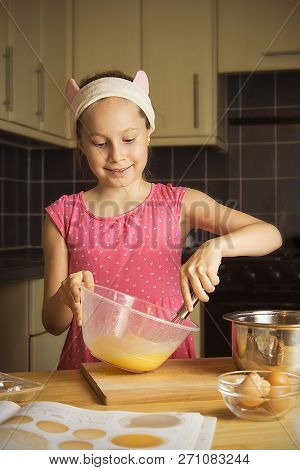 Cute Little Girl Cooking Muffins At Kitcen. Close Up Portret.