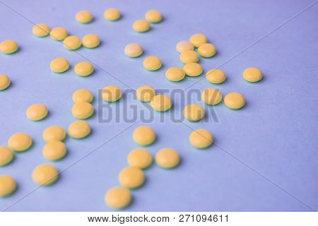 Small Yellow Orange Beautiful Medical Pharmaceptic Round Pills, Vitamins, Drugs, Antibiotics On A Bl