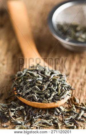 Dried Green Tea Leaves On Wooden Spoon, Photographed On Wood (selective Focus, Focus One Third Into 