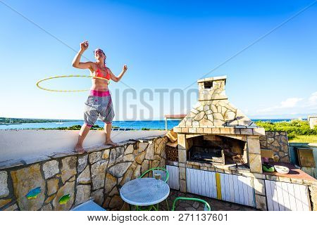 Attractive Adult Woman Is Playing With Hula Hoop In Nature.