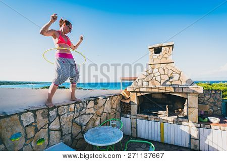 Attractive Adult Woman Is Playing With Hula Hoop In Nature.