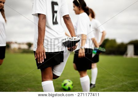 Female soccer team players stretching pre game