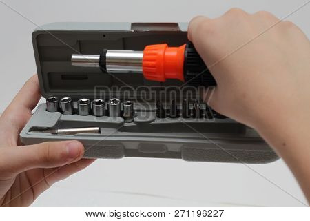 Master Holds In His Hands A Screwdriver. Screwdriver Set In Box On White Background.
