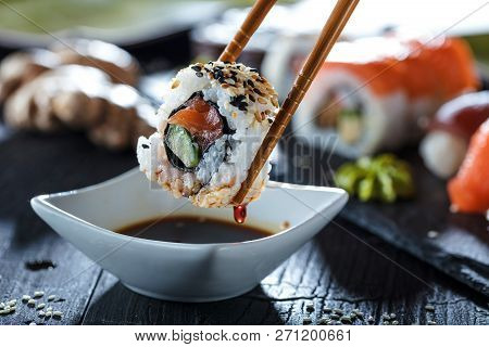 Sushi Set Sashimi And Sushi Rolls Served On Stone Slate.