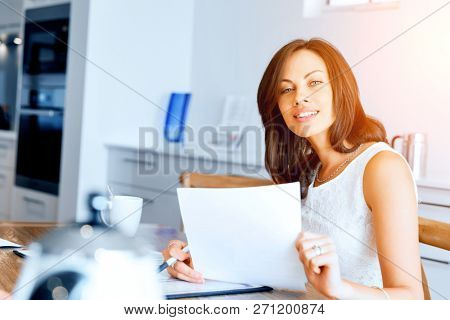 Woman with papers in their living room