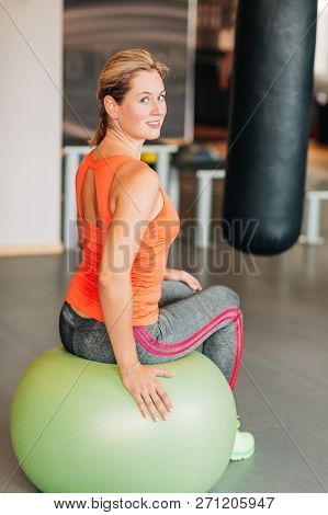 Young Strong Woman Sitting On Fitness Ball