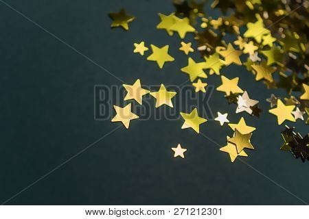 Golden Confetti Stars Scattered On The Surface.