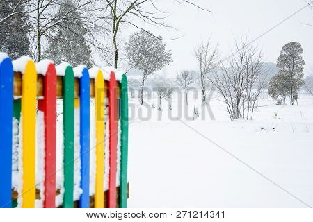 Colorful Fence In Snowy Park With Trees
