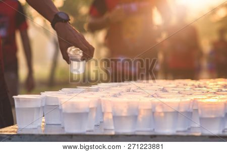 Marathon Runner Take A Water At A Service Point In A Marathon Race With Sunrise, Selective Focus, Sh
