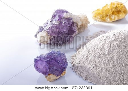 A Pile Of Processed Fluorine Powder Spar Surrounded By Mineral Fluorite Stones Isolated On White.