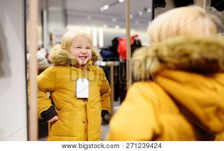 Cute Little Boy Trying New Coat During Shopping. Fashion Warm Clothes For Fall Or Winter. Kid/child 