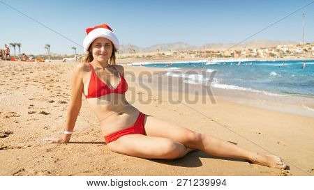 Young Sexy Woman Wearing Santa Clauss Hat Relaxing On The Beach