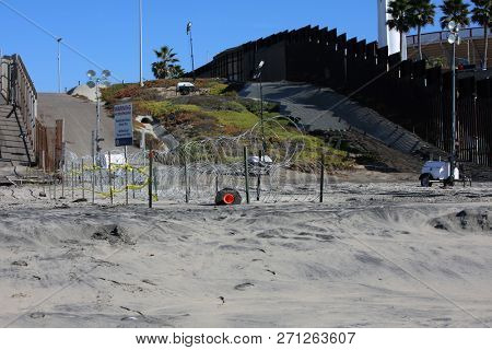 San Ysidro, California - 11/26/2018: Border fence between the USA and Mexico including New Construction adding an additional layer of fencing and razor wire or barbed wire to secure the border.