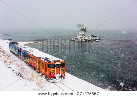 Amaharashi Coast Quasi-national Park, Japan - JANUARY 23, 2017: A Himi Line Train passes the Amaharashi Coast during winter.